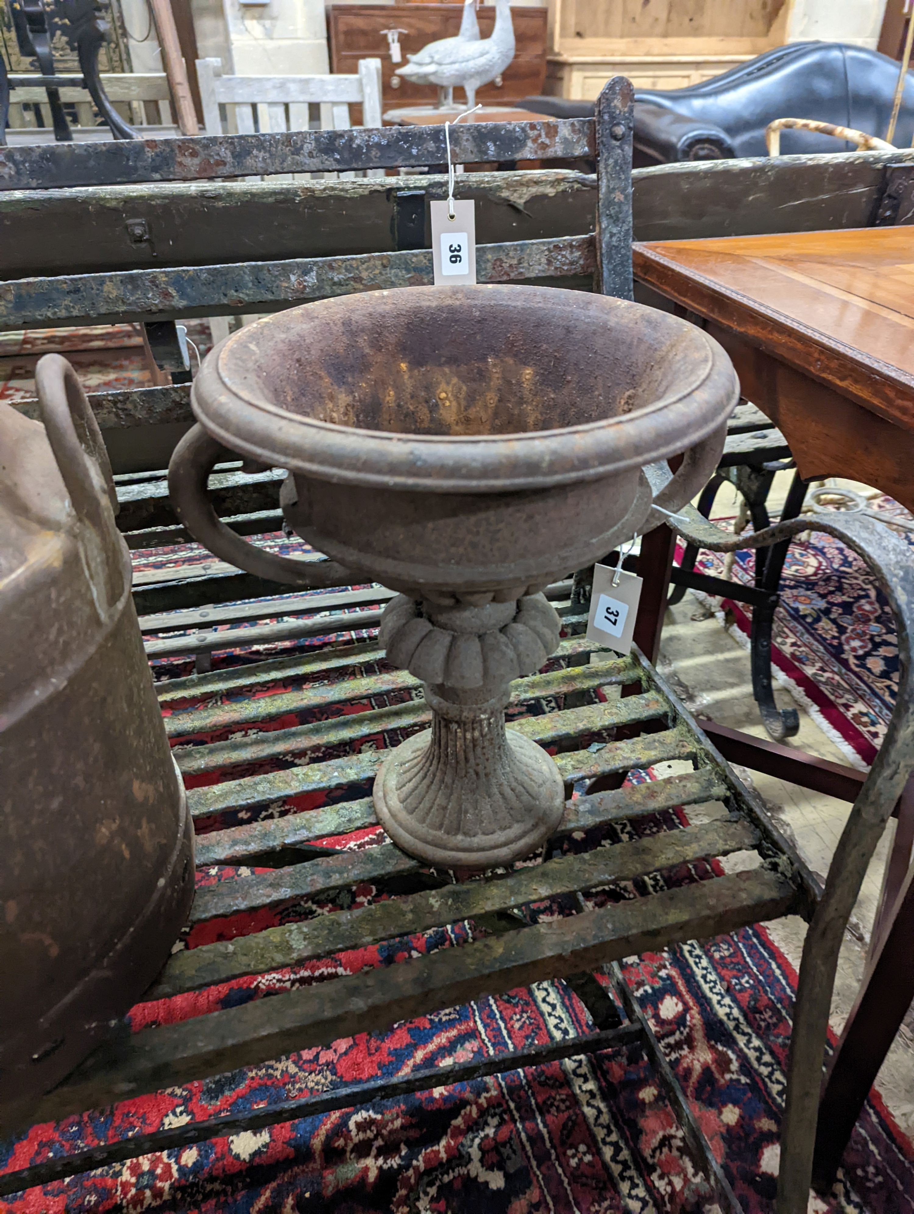 A pair of circular cast iron campana urns, diameter 29cm, height 35cm together with an iron milk churn